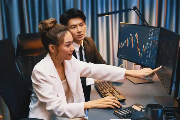 Cinematic scene of a trader analyzing Forex market late evening, illuminated by multiple screens with charts and data, calm focused posture, modern desk setup, soft light contrast, abstract price lines floating slightly in the air, minimalistic fintech aesthetic, deep shadows and volumetric lighting, premium editorial look, horizontal format